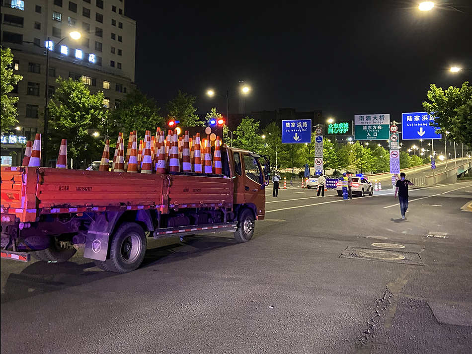 2022年5月31日晚11时，上海浦西，通往浦东的南浦大桥前，董家渡上引桥入口处，施工人员正在准备拆除路障设施。澎湃新闻记者 乐浴峰 图