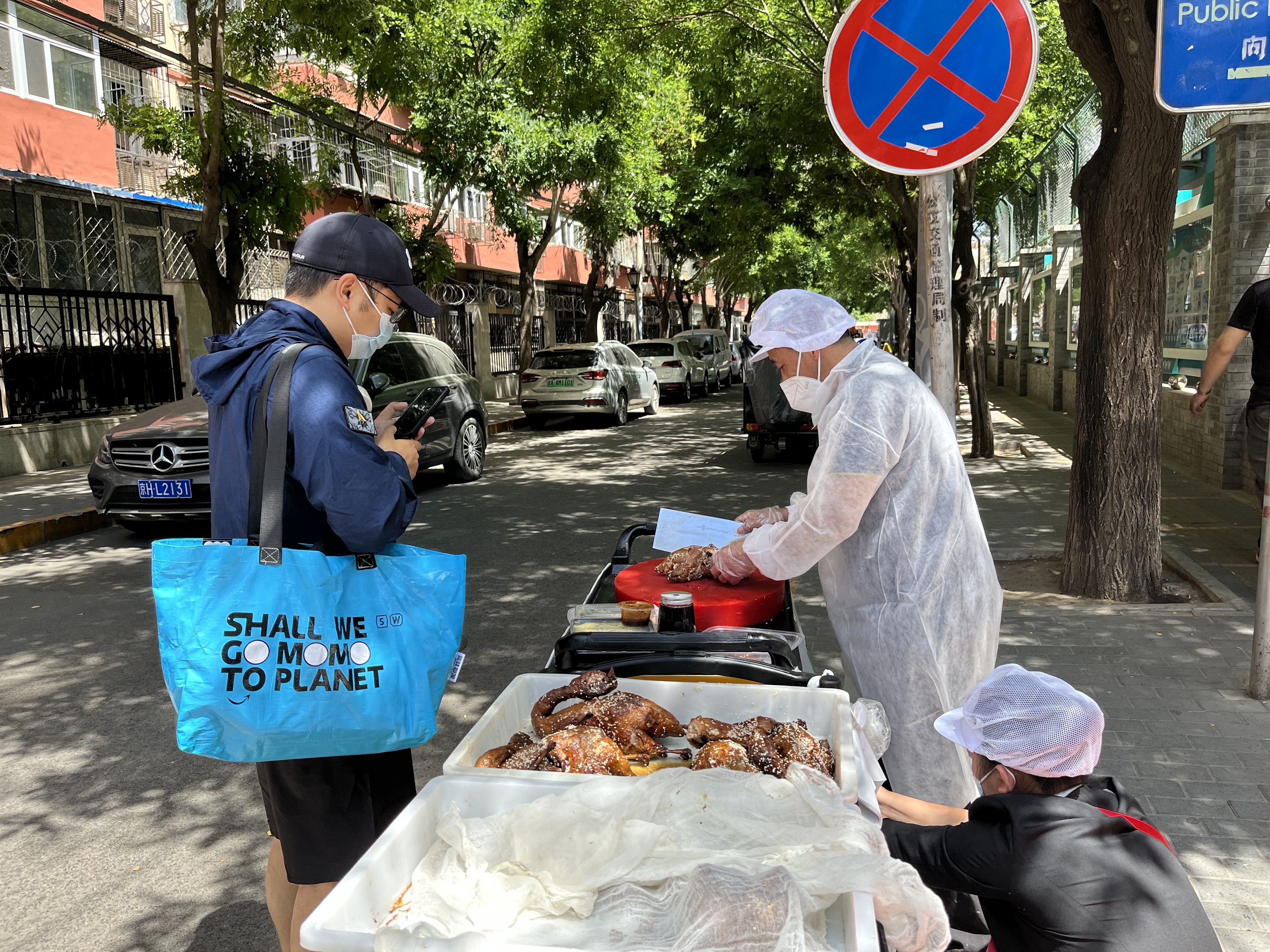 5月25日正午，朝阳区石佛营东里居民区，眉州东坡泛海店员工徐叔正在路边为顾客剁鸭。新京报记者 吴淋姝 摄