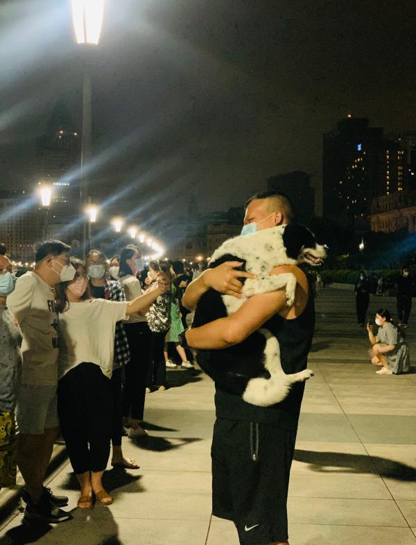 凌晨时分 一个男人抱着爱犬在黄浦江畔吹风