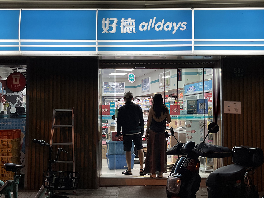 5月31日晚近11时，两名顾客在巨鹿路上一家便利店门口。澎湃新闻记者 邹佳雯 图