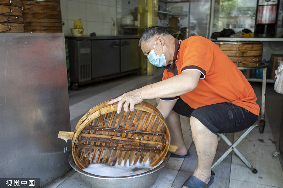 2022年5月31日，上海，包子店工作人员在洗刷蒸笼。视觉中国 图