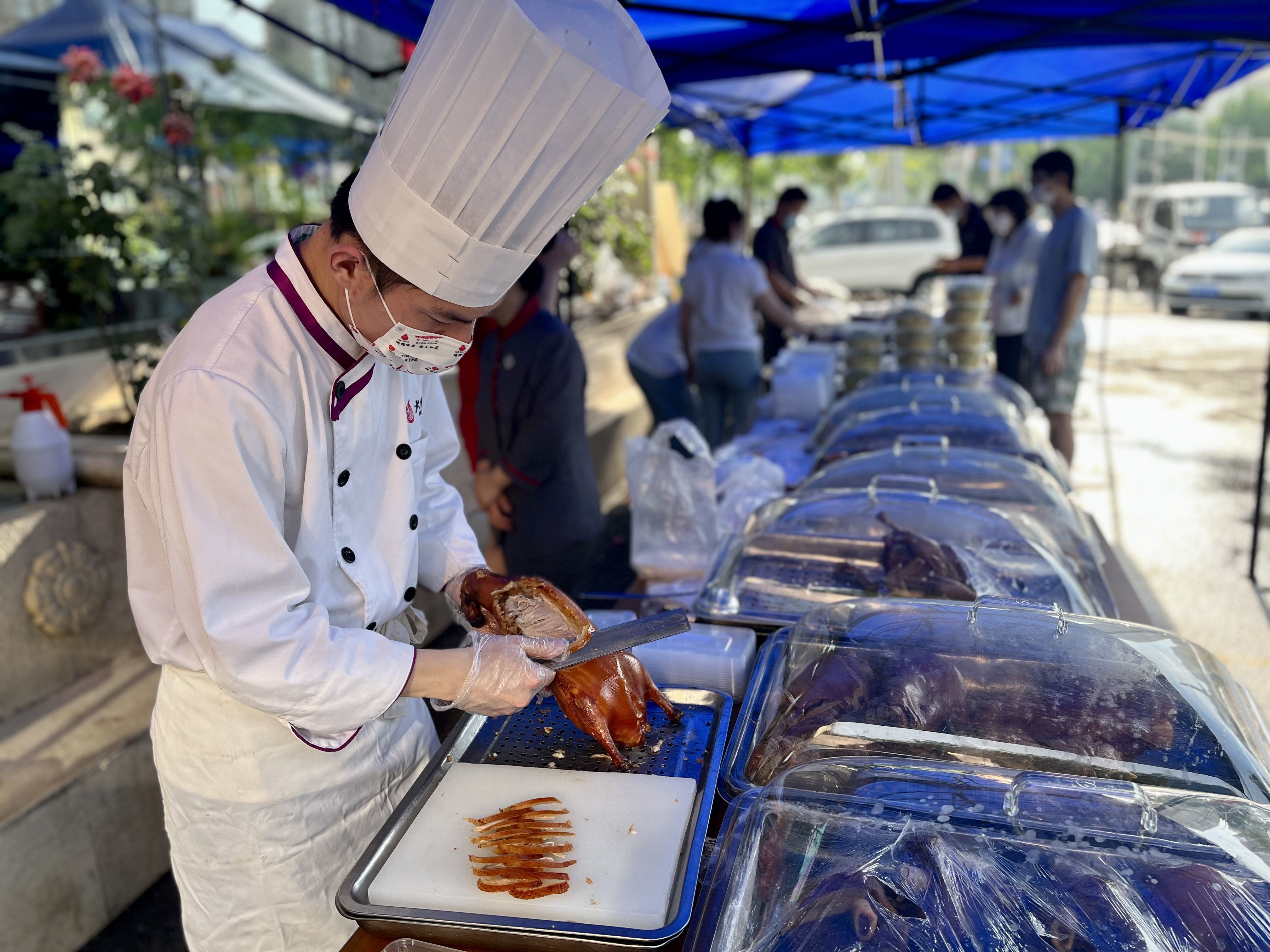 5月24日傍晚，大鸭梨石佛营店迎来晚市高峰，厨师吴师傅在摊位片鸭。新京报记者 吴淋姝 摄