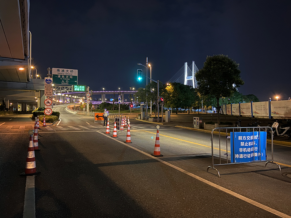 2022年5月31日晚10时，上海浦西，通往浦东的南浦大桥前，交警还在把守瞿溪路引桥入口，路障设施还在。澎湃新闻记者 乐浴峰 图