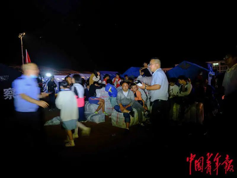 6月1日晚，四川雅安宝兴县七一初级中学体育场安置点，受灾群众在室外等待安置。程雪力/摄