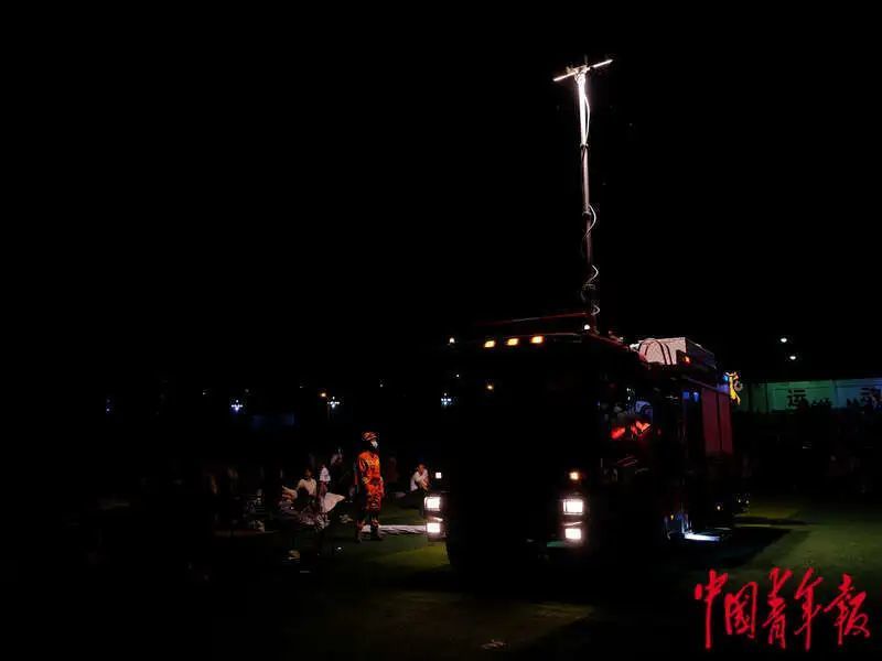 6月1日晚，四川雅安宝兴县七一初级中学体育场安置点，消防车为搭设帐篷提供照明。程雪力/摄