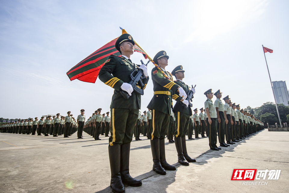 为新战士佩戴军衔标志迎武警部队旗进场参加仪式的官兵整齐列队