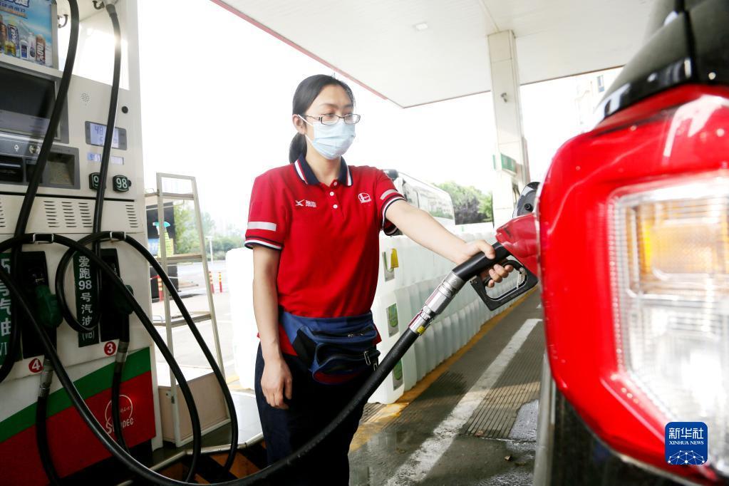 6月14日，在江苏省连云港市一加油站，工作人员给车辆加油。新华社发（王春 摄）