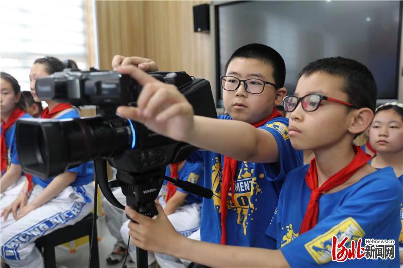 图为“录像师”在河北省张家口市桥东区五一路小学电影拍摄现场调整镜头。
