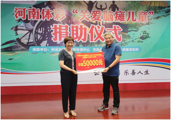 王海新（左）代表河南省体彩中心向汝州市金庚医院宋兆普院长捐助爱心物资