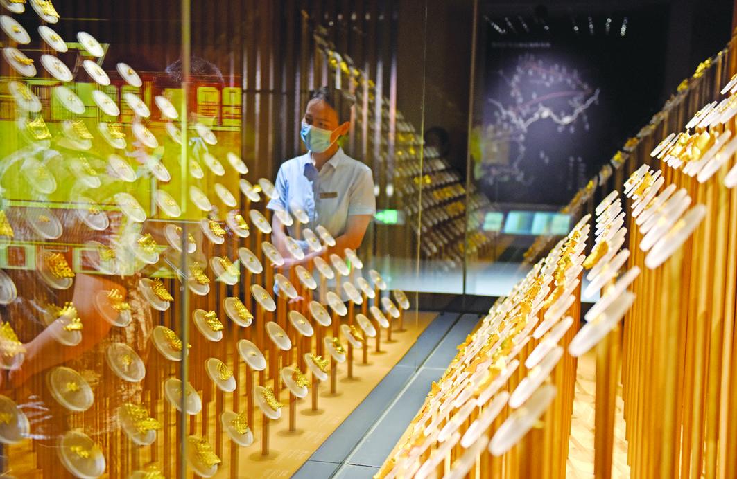 安徽楚文化博物馆讲解员向游客介绍楚金币。