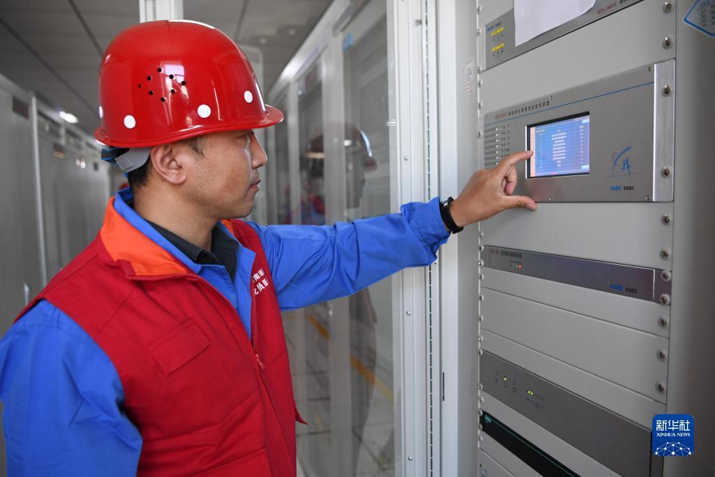 全景监控系统项目经理孙宁在华能集团西坡光伏电站机房内检查设备运行情况(6月13日摄) 新华社记者 陈斌 摄