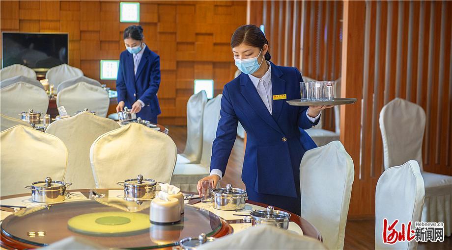 6月20日，在位于石家庄市新华区的一家酒店里，餐厅的服务人员按规定佩戴口罩上岗工作。记者田明摄