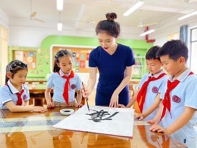 杭州市上城区教育系统把党史学习教育、宋韵文化、廉洁文化融入到清廉学校建设中，为广大师生提供精神养分，提升清廉学校建设的知晓度、参与度、满意度。图为该区澎博小学教师为孩子们现场书写“廉”字，通过廉洁文化浸润，为孩子们的心灵种下清廉种子。杭州市上城区纪委监委 张宇骞 摄