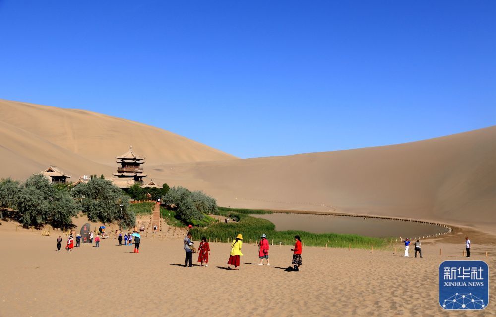 6月19日，游客在甘肃省敦煌市鸣沙山月牙泉景区游览。