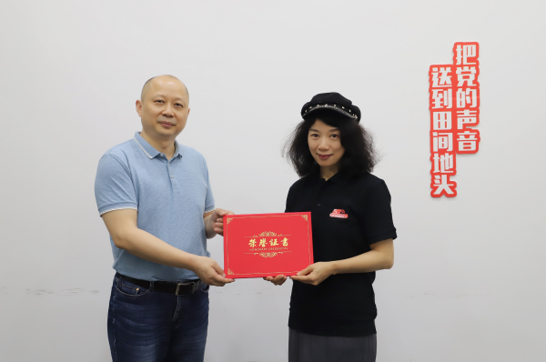 中广联合会智能全媒体委员会副会长兼秘书长李永刚向湖南广电5G智慧电台项目负责人黄荣颁发“全媒体专家智库”荣誉导师聘书