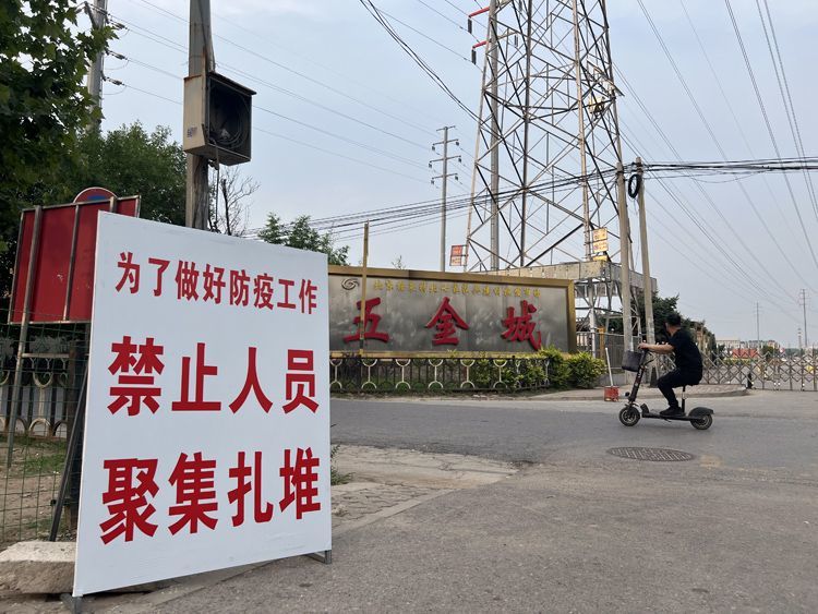 6月20日，北七家建材批发市场门口的防疫提示牌。
