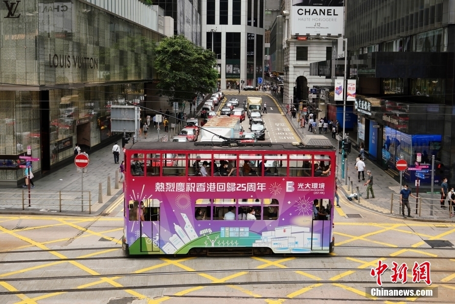 6月21日，一辆车身贴有庆祝香港回归25周年的电车经过中环街头。随着香港回归25周年纪念日临近，香港街头到处洋溢着庆回归的喜庆气氛。 中新社记者 张炜 摄