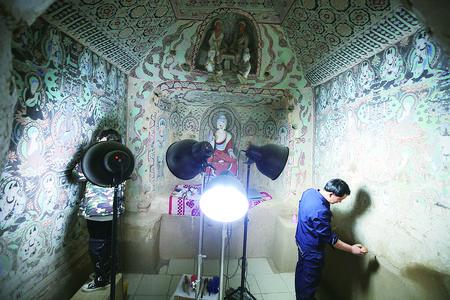 工作人员在莫高窟27窟修复壁画