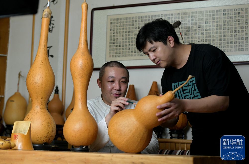 6月18日，民间艺人曹磊（左）在石家庄市新华区工作室指导学员进行葫芦传统器具制作。