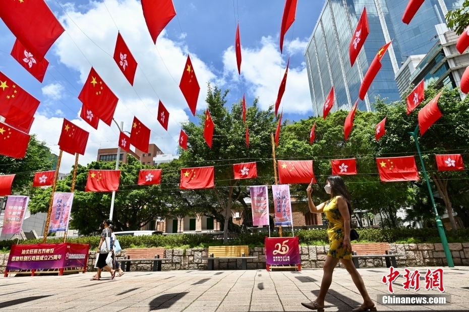 6月27日，市民拍摄尖沙咀栢丽购物大道上的国旗及区旗。 中新社记者 李志华 摄