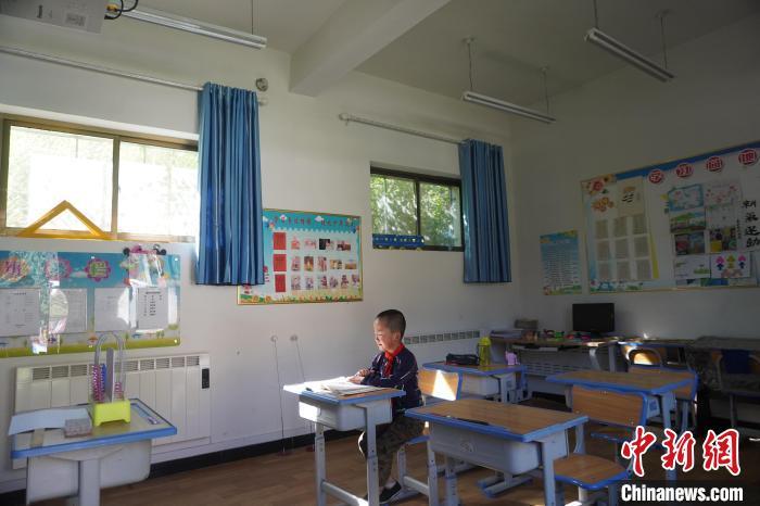 金宇在教师早读，复习前一天的教学内容，只有一人的教室显得有些空荡。　九美旦增　摄