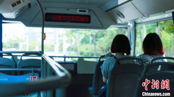 乘客在公交车上，欣赏窗外风景。　丁雷 摄