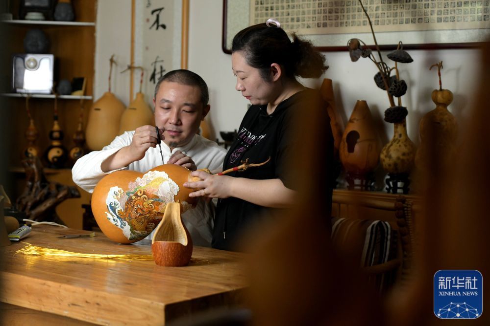 6月18日，民间艺人曹磊（左）在石家庄市新华区工作室进行葫芦传统器具掐丝珐琅工序制作。