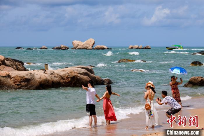 资料图：游客在天涯海角的海边沙滩“拥抱大海”。　范勇 摄