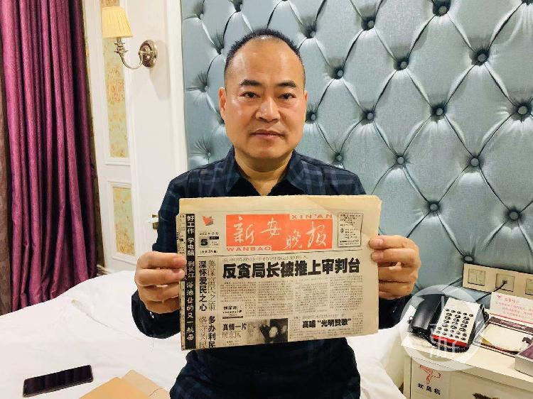 ▲2019年12月11日，李金奎手持当年对他的报道称，这起案件彻底改变了他的人生。摄影/上游新闻记者 时婷婷