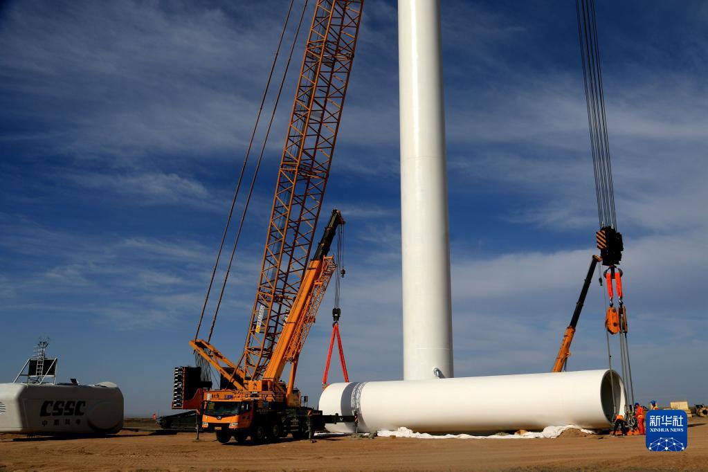 7月2日，在甘肃敦煌海装北湖49.5兆瓦风电项目建设现场，工人在进行吊装作业。新华社发（张晓亮 摄）