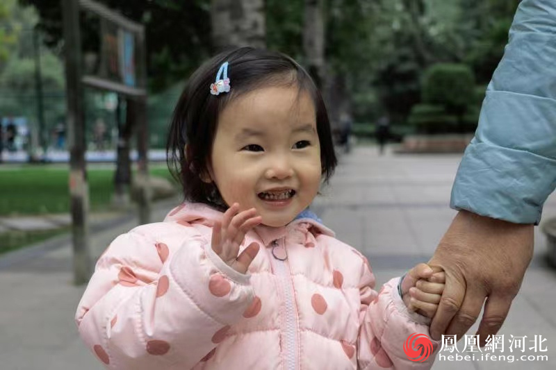 在石家庄的公园内，爷爷带着孙女遛弯玩耍，感受亲近大自然的乐趣，孩子的脸上洋溢出开心的笑容。（网友投稿作品）
