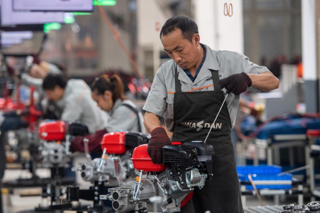 5月30日,在华世丹机械车间内,工人在生产线上组装生产小型农用机械