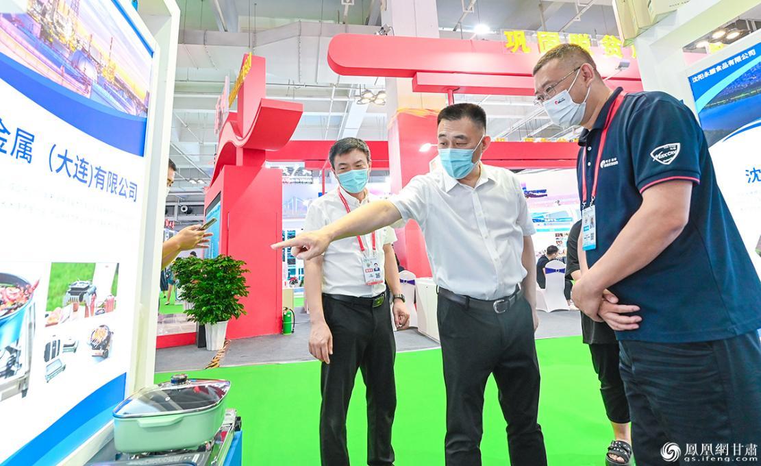 辽宁省商务厅党组成员、副厅长李军(中)了解该省企业在兰洽会的布展情况 李德宇 摄