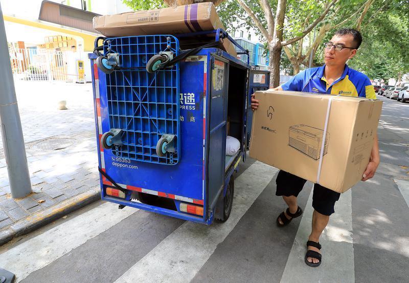 一位快递小哥在西安市碑林区乐居场一小区外,正要将快递送往收件人