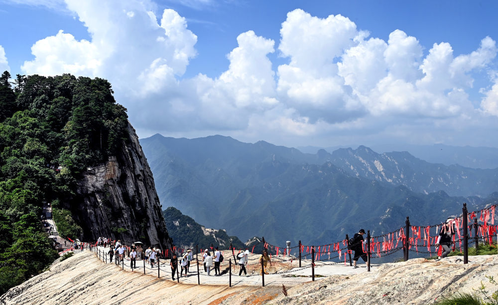 7月10日,游客在攀登华山西峰青龙背