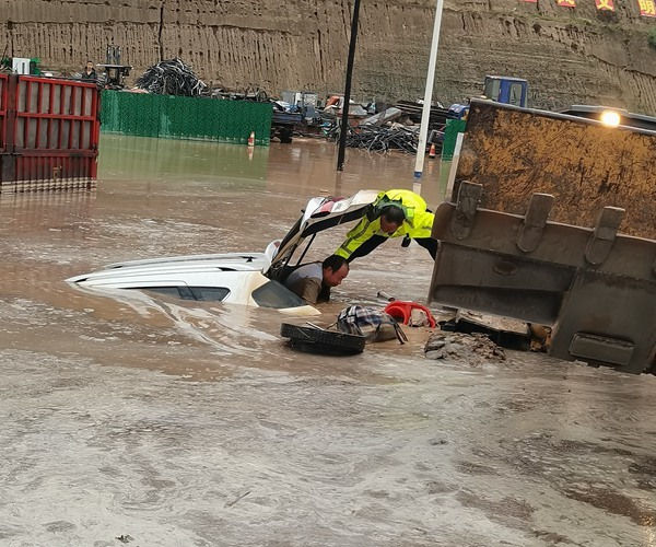 近日，甘肃庆阳市境内出现强降雨天气，图为环县山城乡派出所民警自驾装载机与交警联合冒雨救出被困人员。庆阳市委宣传部供图