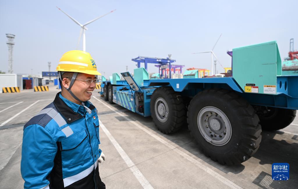 在天津港北疆港区C段智能化集装箱码头，工人参观“水平运输机器人”（2022年4月29日摄）。新华社记者 李然 摄