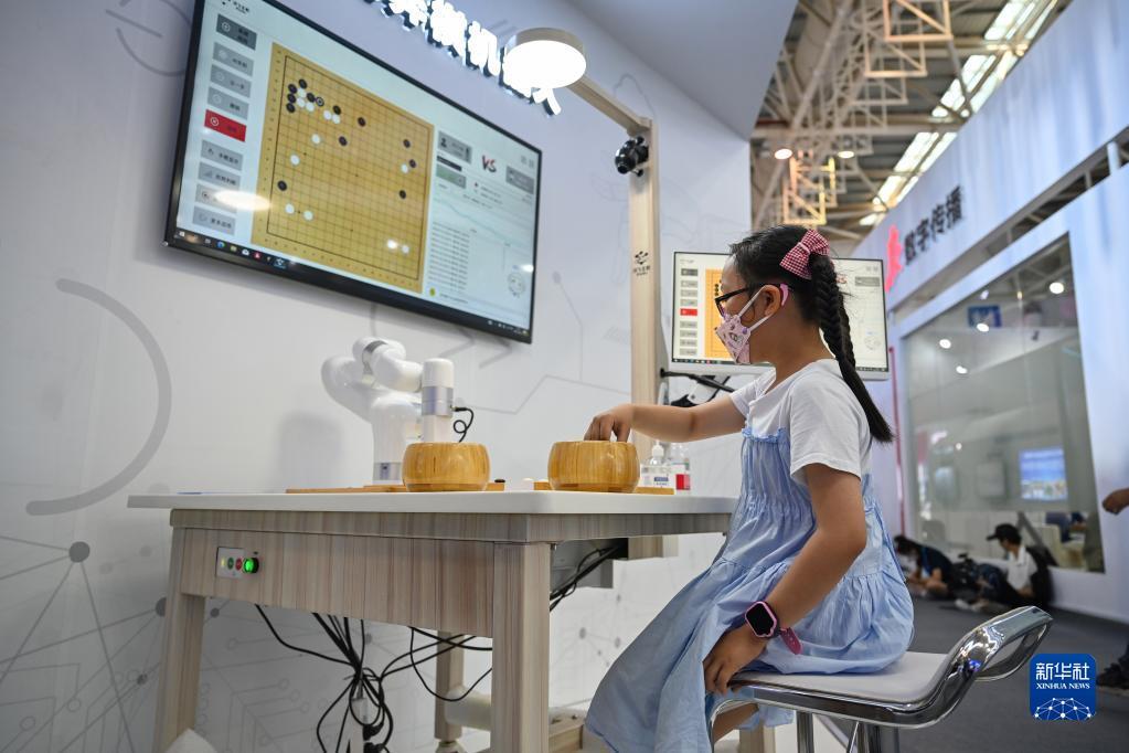 7月22日，小朋友在第五届数字中国建设成果展览会上和AI机器人下棋。 新华社记者 周义 摄