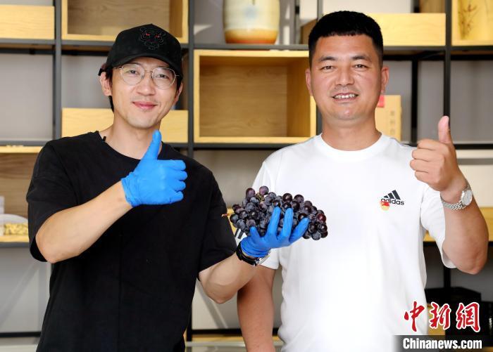 在河北省大厂回族自治县小厂村,村党支部书记马强(右一)通过短视频平台为村民直播带货。 刘亮 摄