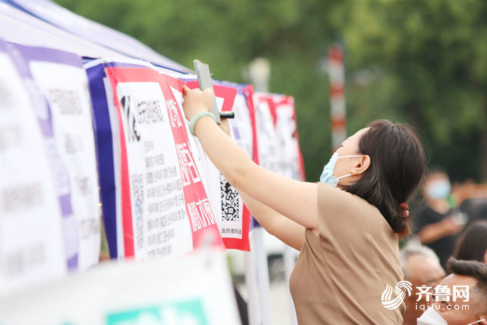 图/6月30日，山东济宁，求职者在邹城市助企攀登招聘会现场了解招聘信息