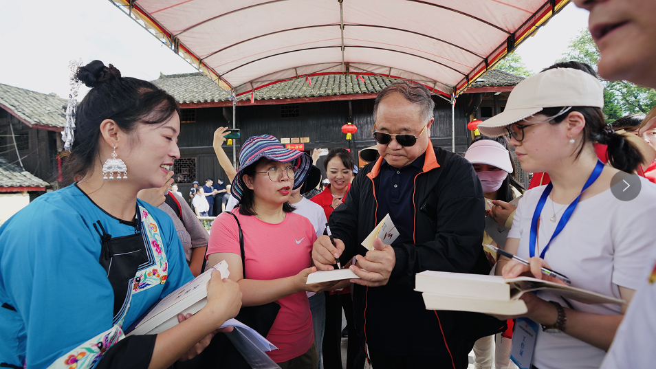 ▲ 7月30日，十八洞村，游客们纷纷请著名作家、诺贝尔文学奖获得者莫言签名。