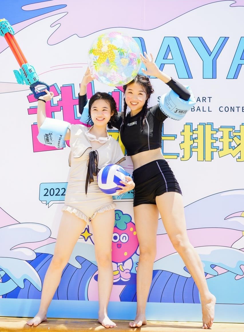 游客在玛雅海滩前抱着排球欢乐合影。