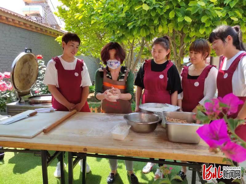 在廊坊，香河肉饼技能培训走进美丽庭院。图为香河肉饼技艺培训讲师刘建蓬向村街妇女姐妹面对面教授肉饼制作技能。香河县妇联供图