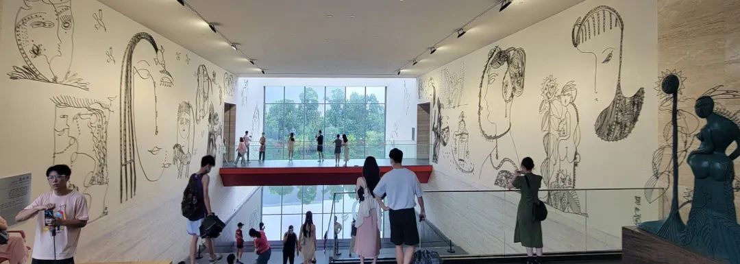 诗人丹慧，无师自通，以其灵性线描画作做成的巨幅壁画——《慧世界》，成为李自健美术馆的一道靓丽风景、文化新地标中的网红打卡地。