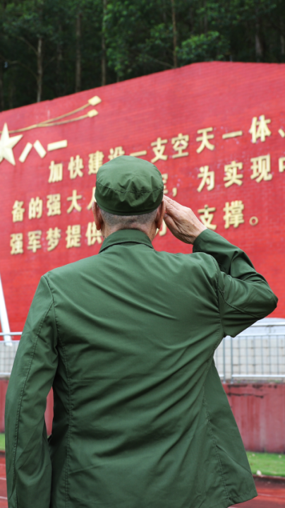 白永发：1932年出生，1948年入伍，1950年加入中国共产党。“八一”前夕，白永发重回老部队，在营区的军旗雕塑前，庄严敬礼。