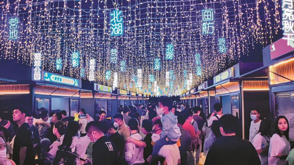 长春北湖柳堤消夏节夜市区，悬挂在街道上空的彩灯网让游客仿佛来到魔幻空间。