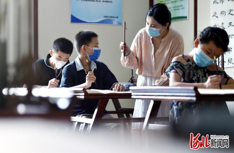 8月5日，河北省石家庄市阳光小学的学生在暑期托管课上练习书法。
