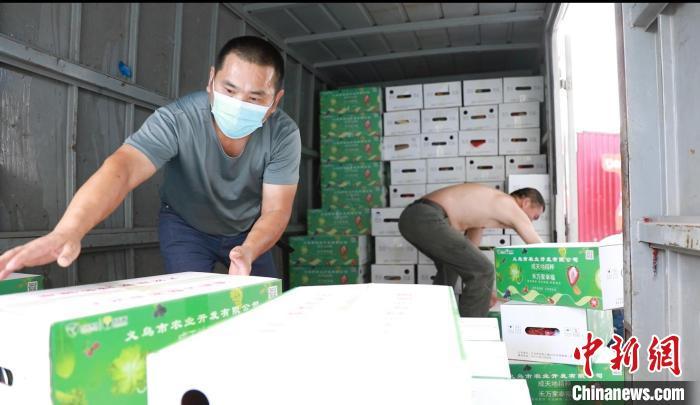 义乌两名工人搬运防疫物资包。　陈华超 供图