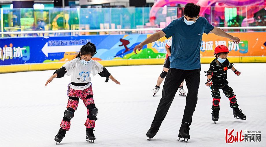7月26日，在石家庄天山海世界滑冰场，小学员在教练的指导下练习花样滑冰基本技术。 河北日报记者耿辉摄
