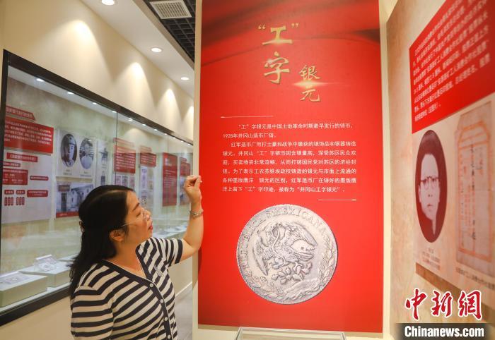 金花正在介绍“工”字银元。　刘力鑫 摄